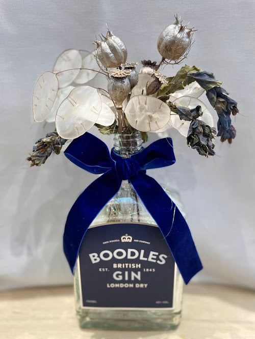 Boodles gin bottle bouquet with lunaria and silver poppy seedheads