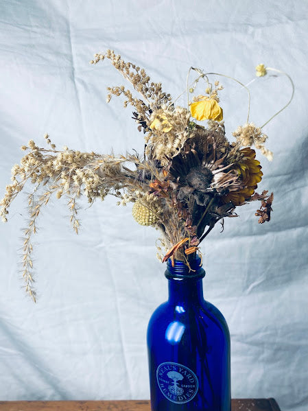 Neal's Yard blue glass bottle 100ml with golden buttercup posy