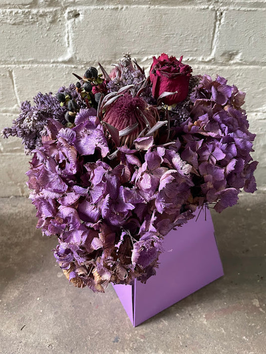 Deep purple dried hydrangea and red rose hat box bouquet