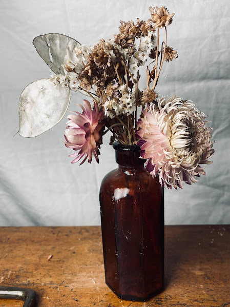 Pink posy in antique brown glass bottle