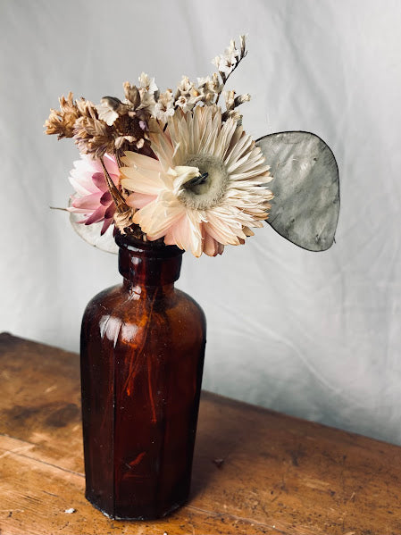 Pink posy in antique brown glass bottle